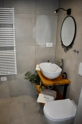 a bathroom with a sink and a toilet and a mirror at Vila Imenja in Šmartno