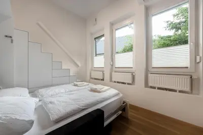 a bedroom with a bed and three windows at Apartma Juniper in Kranjska Gora