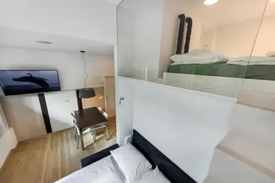 a small room with a bed and a tv at Apartma Juniper in Kranjska Gora