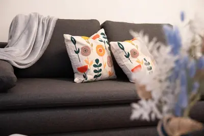 a gray couch with two pillows on it at Cosy Castle Flat in Ljubljana Center - FREE PARKING in Ljubljana