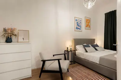 a bedroom with a bed and a chair at Cosy Castle Flat in Ljubljana Center - FREE PARKING in Ljubljana