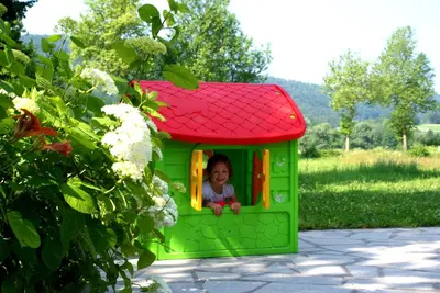 a little girl is looking out the window of a toy house at Apartments Leni in Postojna