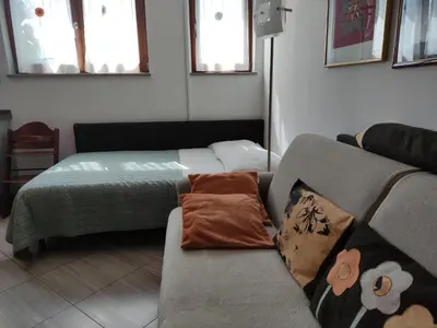 a living room with a couch and a bed at Apartments Leni in Postojna