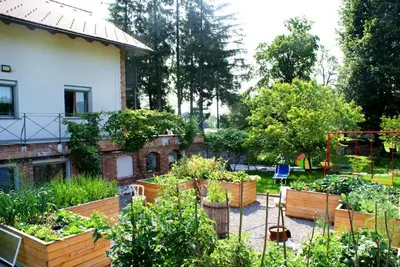 a garden in front of a house with wooden boxes at Apartments Leni in Postojna