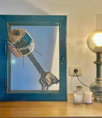 a picture in a blue frame next to a lamp and a candle at Kraska nisa in Komen