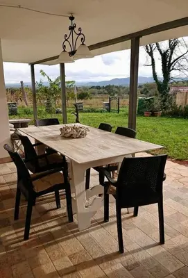 a table with chairs and an umbrella on a patio at Kraska nisa in Komen