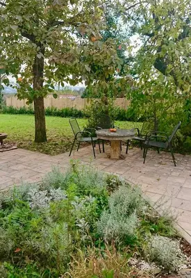a picnic table and two chairs in a park at Kraska nisa in Komen
