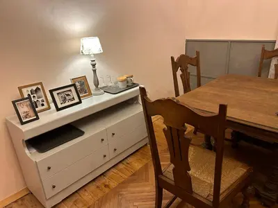 a dining room with a table and a white dresser at Kraska nisa in Komen