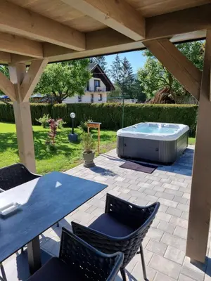 a patio with a table and chairs and a hot tub at Apartments Boldin in Bled