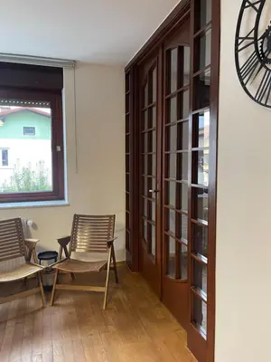 a room with two chairs and a table and a clock at Spacious Cozy apartment in Ljubljana