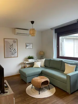 a living room with a green couch and a table at Spacious Cozy apartment in Ljubljana