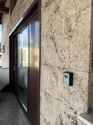 a sliding glass door on a stone wall at Spacious Cozy apartment in Ljubljana