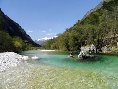 a person in a kayak on a river in the mountains at Apartments Dvor in Bovec