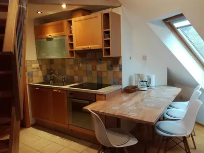 a kitchen with a sink and a table with chairs at Apartments Dvor in Bovec