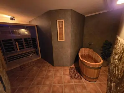 a bathroom with a wooden tub in a room at Apartments Domačija Mlaker in Podčetrtek