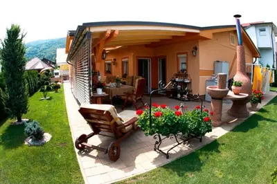 a patio with a chair and flowers in a yard at Rooms Beros in Maribor