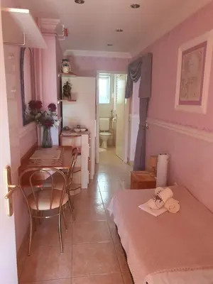 a room with two beds and a table and a kitchen at Rooms Beros in Maribor