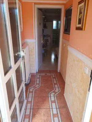 a hallway with orange walls and a tile floor at Rooms Beros in Maribor