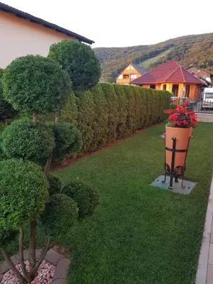 a garden with a bench with a flower pot and bushes at Rooms Beros in Maribor