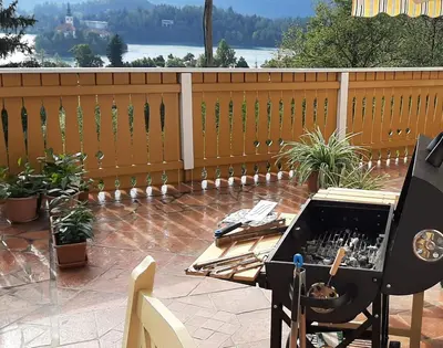 a barbecue on a patio with a table and a grill at Apartment Milly in Bled
