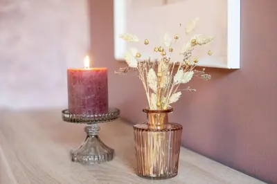 a candle and a vase with flowers on a table at Pretty Jolie Romantic Getaway in Bled