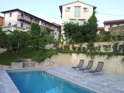 a swimming pool with two chairs next to a building at Boutique Hotel Dvor in Dobrovo