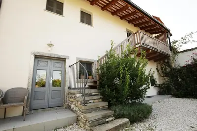a house with a staircase leading to a door at Boutique Hotel Dvor in Dobrovo