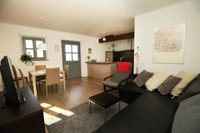 a living room with a couch and a table and a kitchen at Boutique Hotel Dvor in Dobrovo