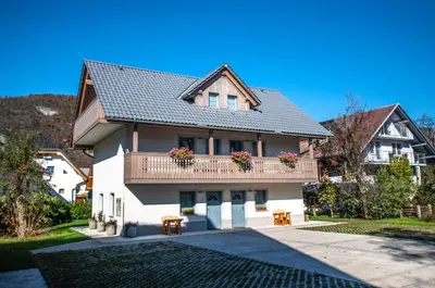 a house with a balcony with two tables at Apartments Francka in Bohinj