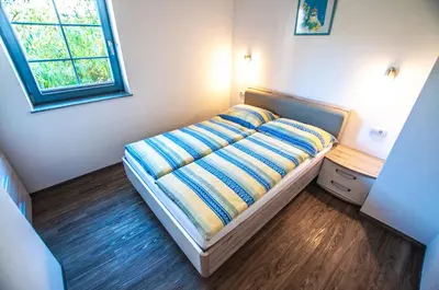 a bed in a room with a window at Apartments Francka in Bohinj