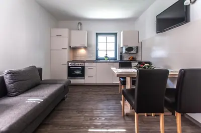 a kitchen and living room with a couch and a table at Apartments Francka in Bohinj