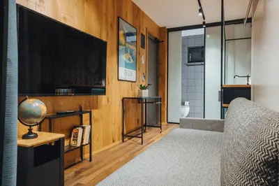 a living room with a television and a couch at City Glamping by ONE66 Hotel in Ljubljana