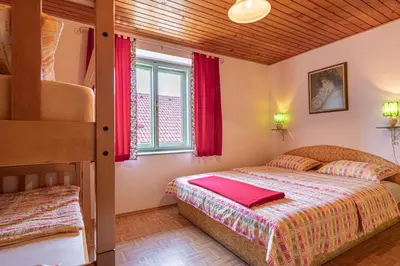 a bedroom with two beds and a bunk bed at Lukčeva domačija počitniška hiša - Happy Rentals in Kostel
