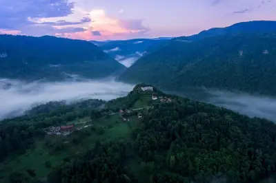 an aerial view of a mountain with clouds and trees at Lukčeva domačija počitniška hiša - Happy Rentals in Kostel