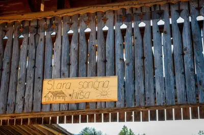 a sign on the side of a wooden fence at Stara sončna hiša in Radovljica
