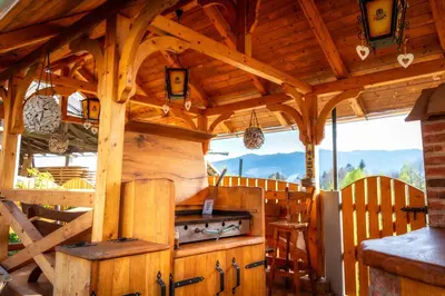 an outdoor kitchen with a stove in a wooden building at Stara sončna hiša in Radovljica