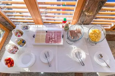 a white table with plates and bowls of food on it at Guesthouse Živko in Dobrovce