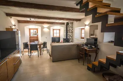 a living room with a couch and a table at SAUNU DVOR in Tolminski Lom