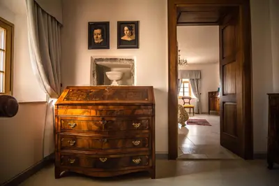 a room with a dresser and a hallway with portraits at SAUNU DVOR in Tolminski Lom