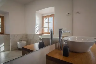 a bathroom with a tub and a sink and a mirror at SAUNU DVOR in Tolminski Lom