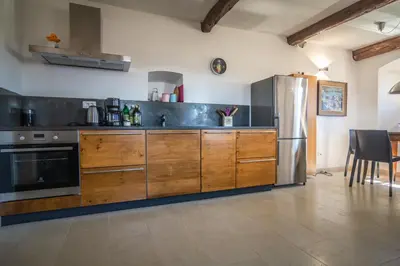 a kitchen with wooden cabinets and a stainless steel refrigerator at SAUNU DVOR in Tolminski Lom