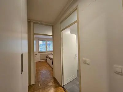 a hallway with a mirror and a bed in a room at Ljubljana Central Suite Martin in the City Center in Ljubljana