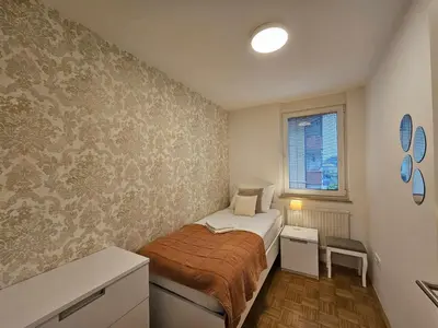 a small bedroom with a bed and a window at Ljubljana Central Suite Martin in the City Center in Ljubljana