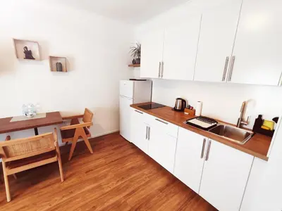 a kitchen with white cabinets and a wooden table at Lucky center Ljubljana in Ljubljana