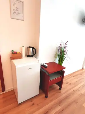 a small refrigerator and a table in a room at Lucky center Ljubljana in Ljubljana
