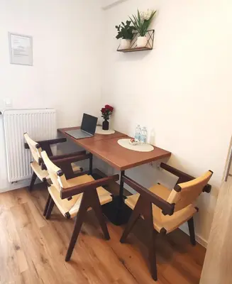 a wooden table with chairs and a laptop on it at Lucky center Ljubljana in Ljubljana