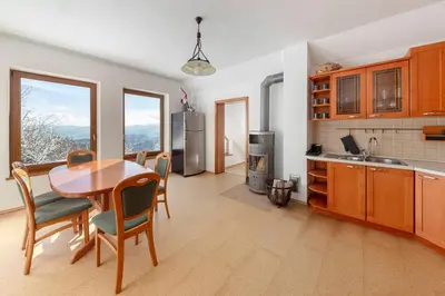 a kitchen with a wooden table and chairs and a kitchen with a tablektop at Guest House Štruc in Slovenj Gradec