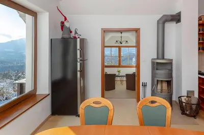 a kitchen with a refrigerator and a table and chairs at Guest House Štruc in Slovenj Gradec