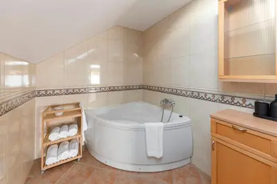 a bathroom with a white tub in a room at Guest House Štruc in Slovenj Gradec