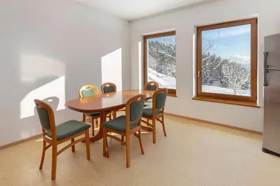 a dining room with a table and chairs and a window at Guest House Štruc in Slovenj Gradec